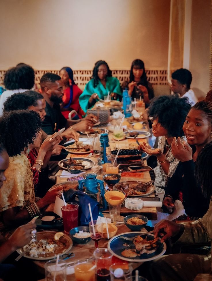 Guests seated around a long table sharing dinner and conversation