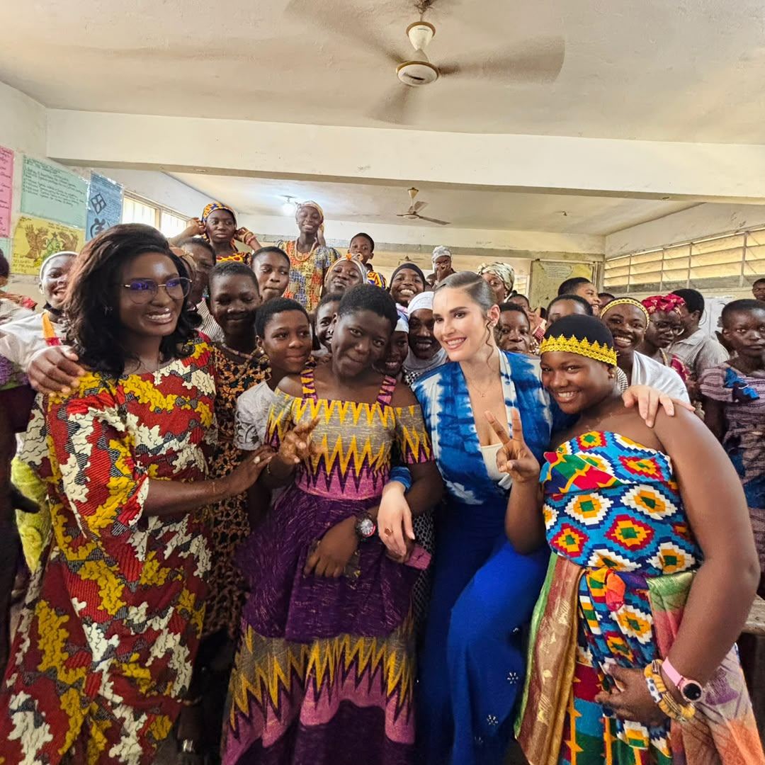 Women in patterned dress standing together at a community event
