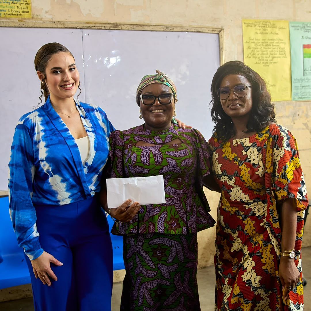 Shalimar Abbiusi standing with two community members holding an envelope